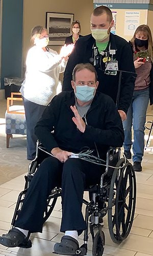 Patient John Alward waves to staff while leaving the Alfond Center for Health in Augusta.