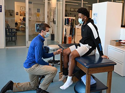 Colby student works on his recovery with MaineGeneral physical therapist Josh Barlow